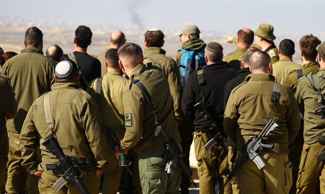 Israeli soldiers look towards Beit Hanoun, as seen from southern Israel